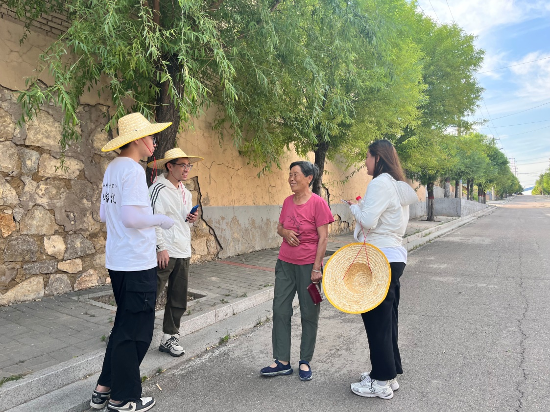 國(guó)土整治與生態(tài)修復(fù)實(shí)踐調(diào)研團(tuán)師生與村民交流。校方供圖